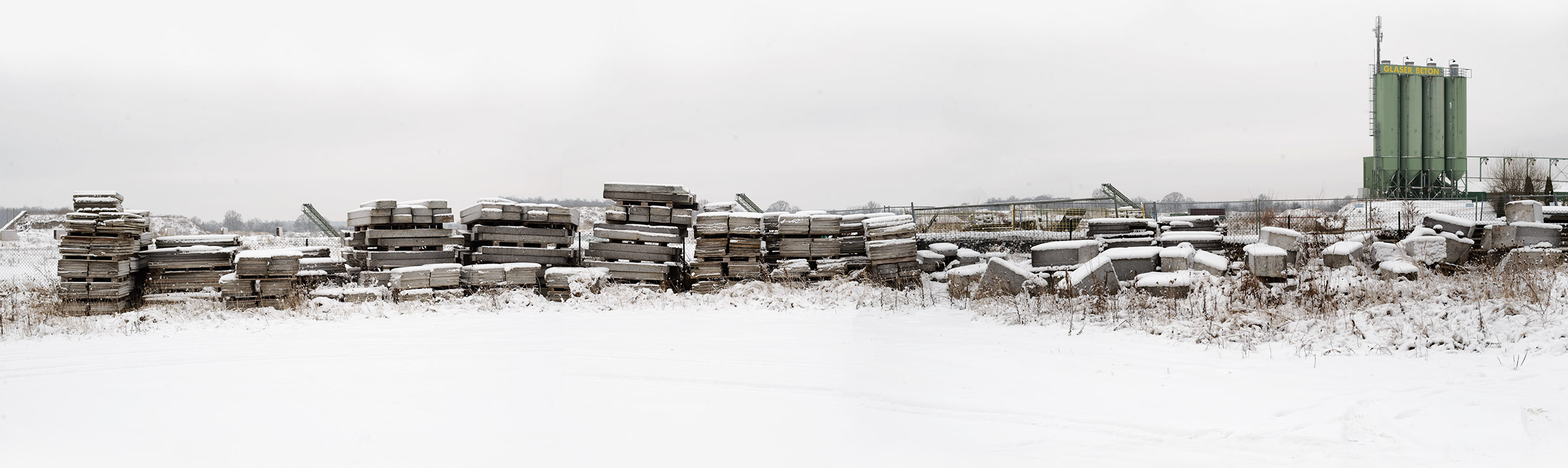 Hunderte Granitplatten liegen schneebedeckt in einem Lager